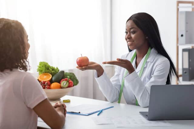 Registered dietitian providing personalized nutrition counseling and healthy eating guidance during a one-on-one consultation.