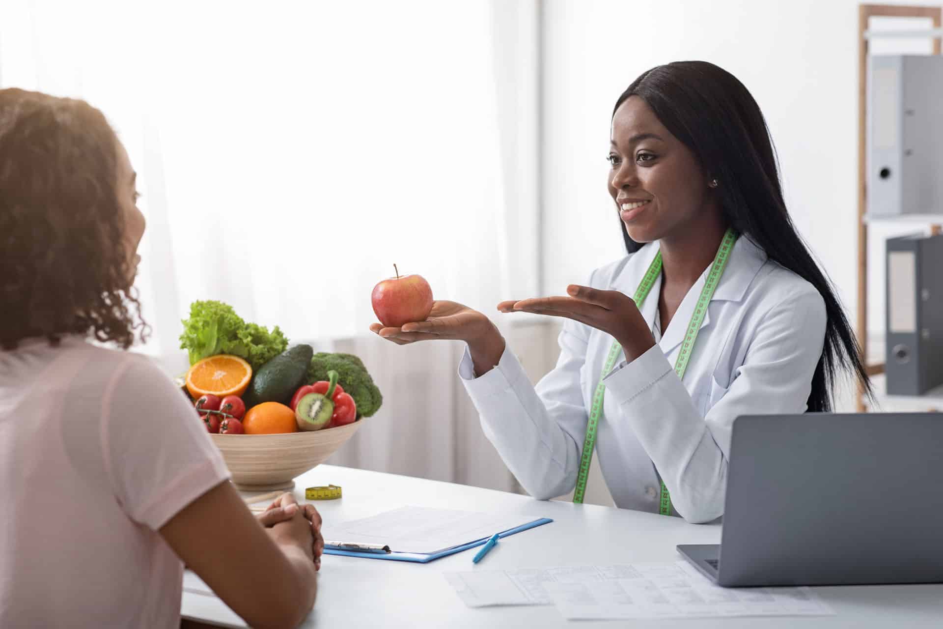 Registered dietitian providing personalized nutrition counseling and healthy eating guidance during a one-on-one consultation.